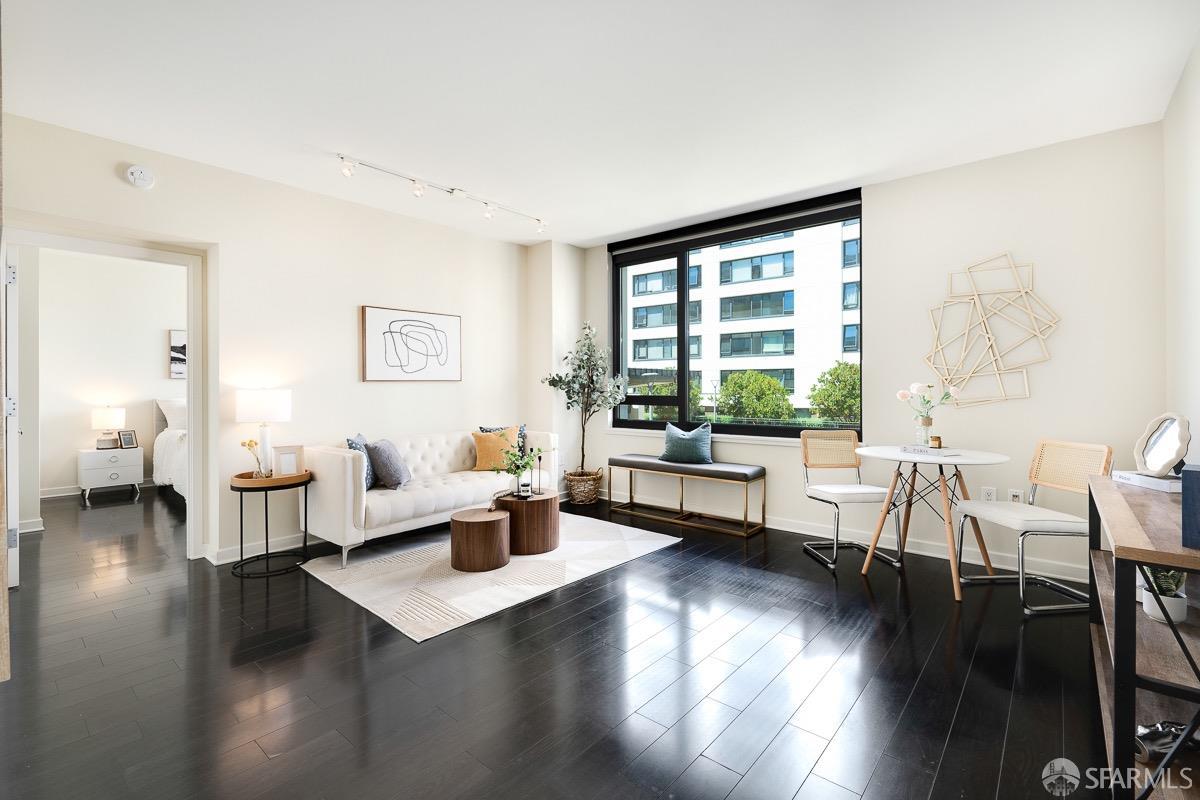 a living room with couches a coffee table and a large window with wooden floor