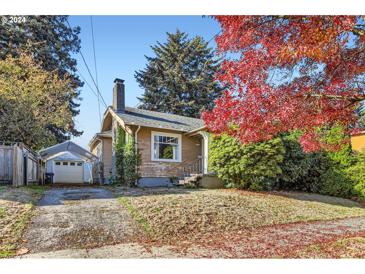 a front view of house with yard and trees in the background