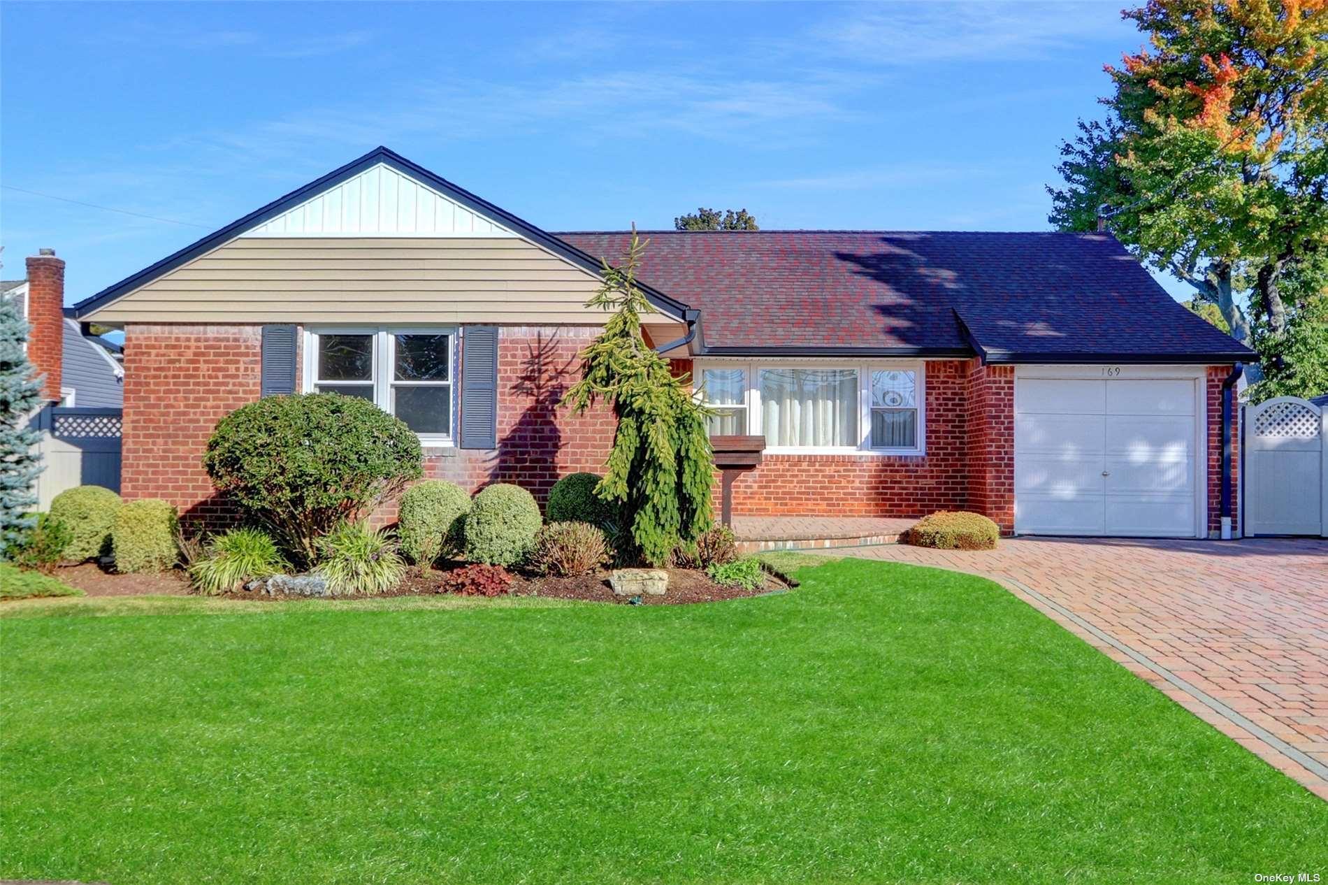 a front view of a house with a yard and potted plants