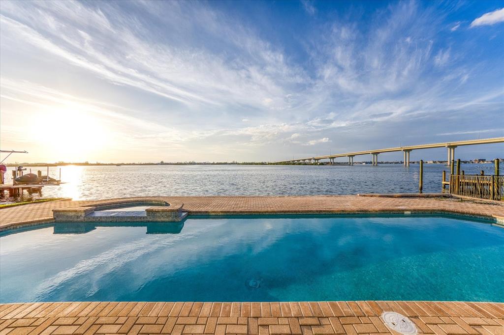 a view of swimming pool with furniture and lake view