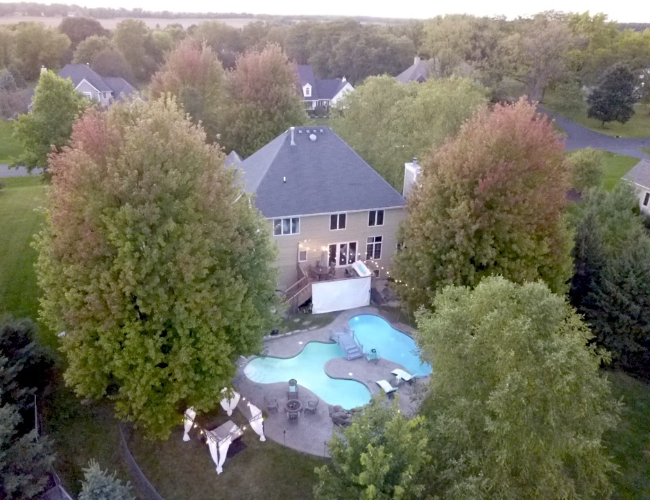 a aerial view of a house with a yard and a large tree