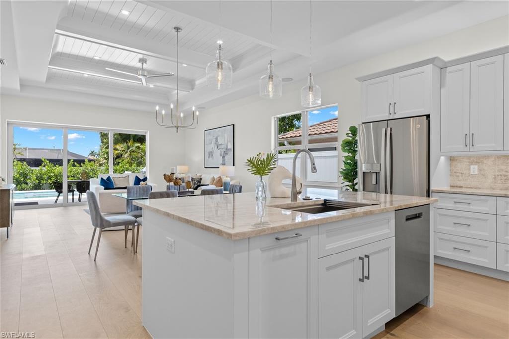 a kitchen with counter top space and living room view