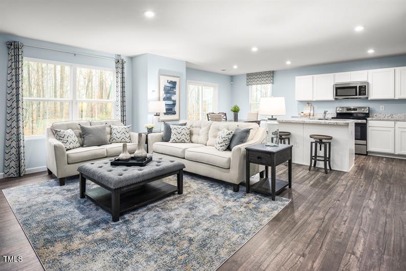 a living room with furniture and a wooden floor