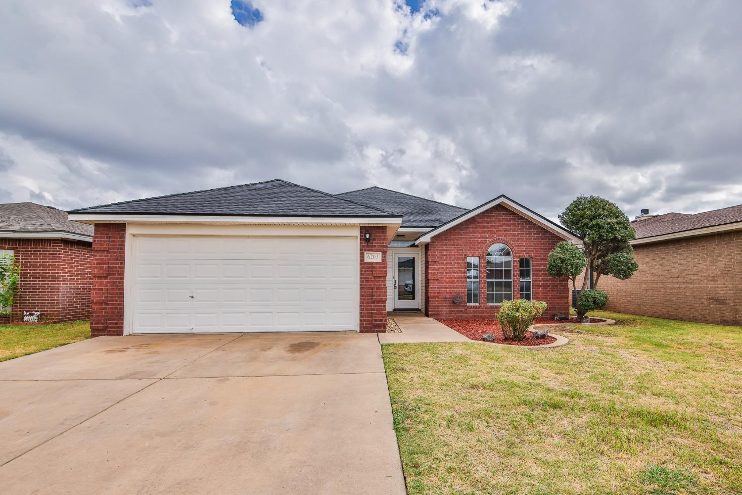 a view of a house with a yard and garage