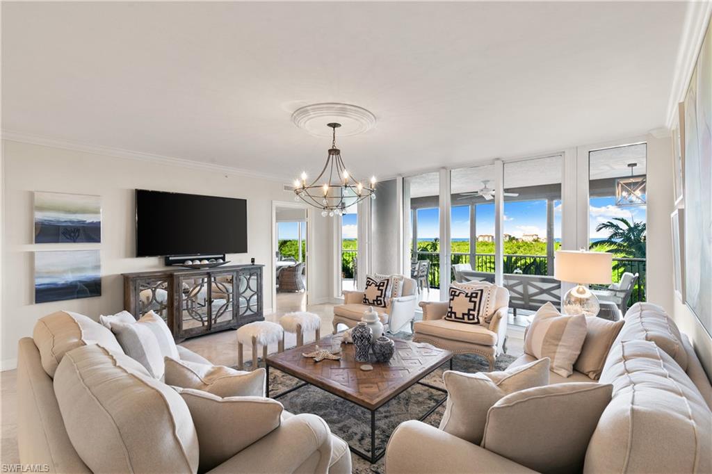 a living room with furniture flat screen tv and a chandelier