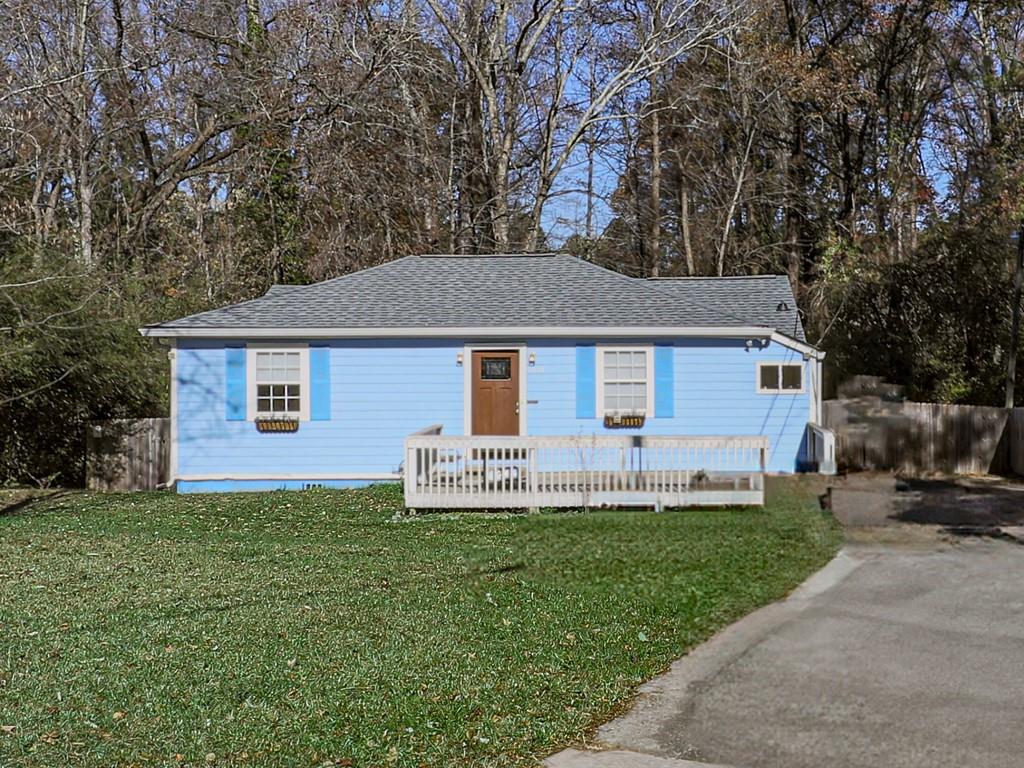 a front view of a house with a yard and trees