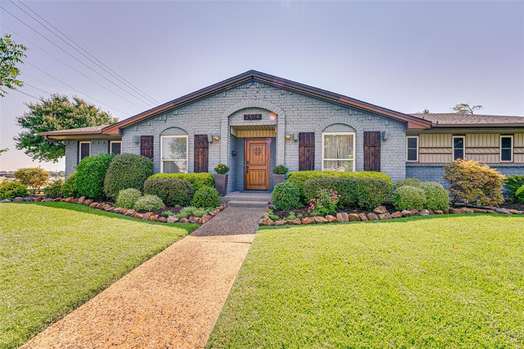 a front view of a house with yard and green space