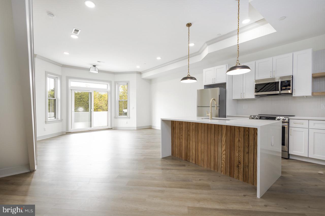 a kitchen with stainless steel appliances granite countertop wooden floors sink and cabinets