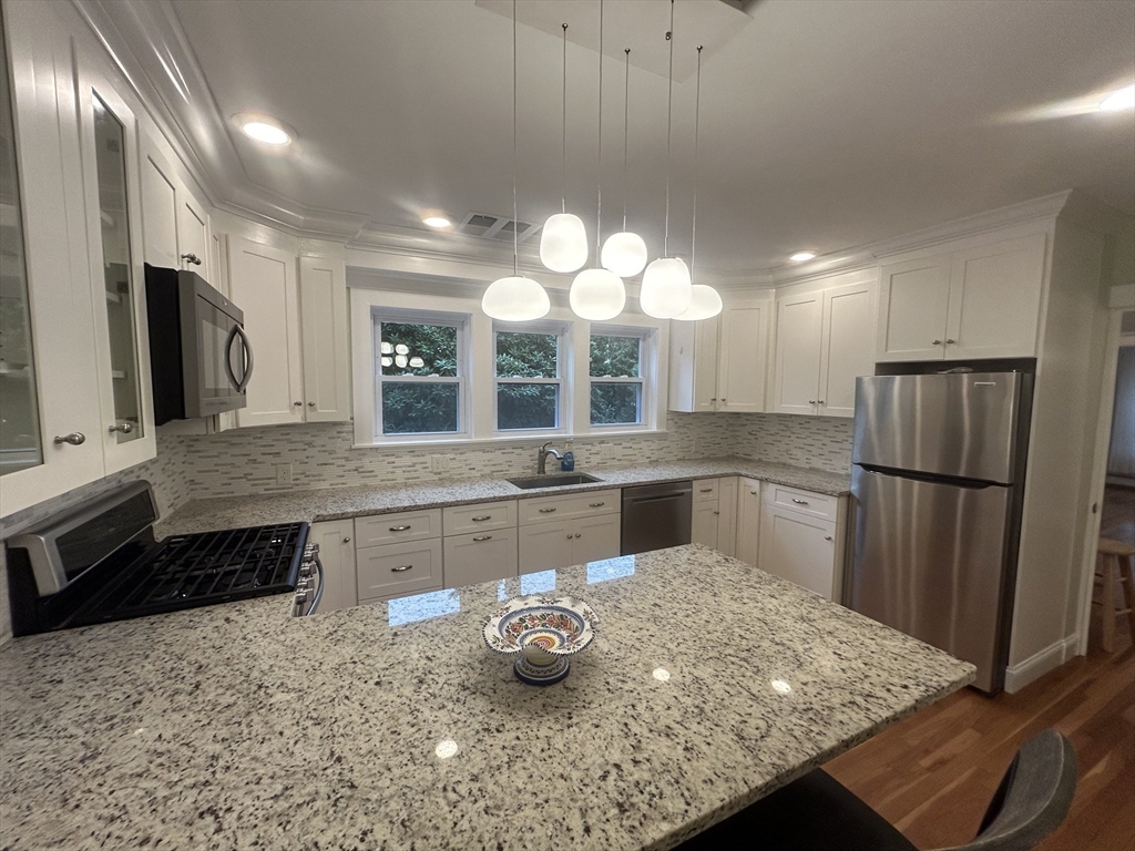 a large kitchen with a large window and stainless steel appliances