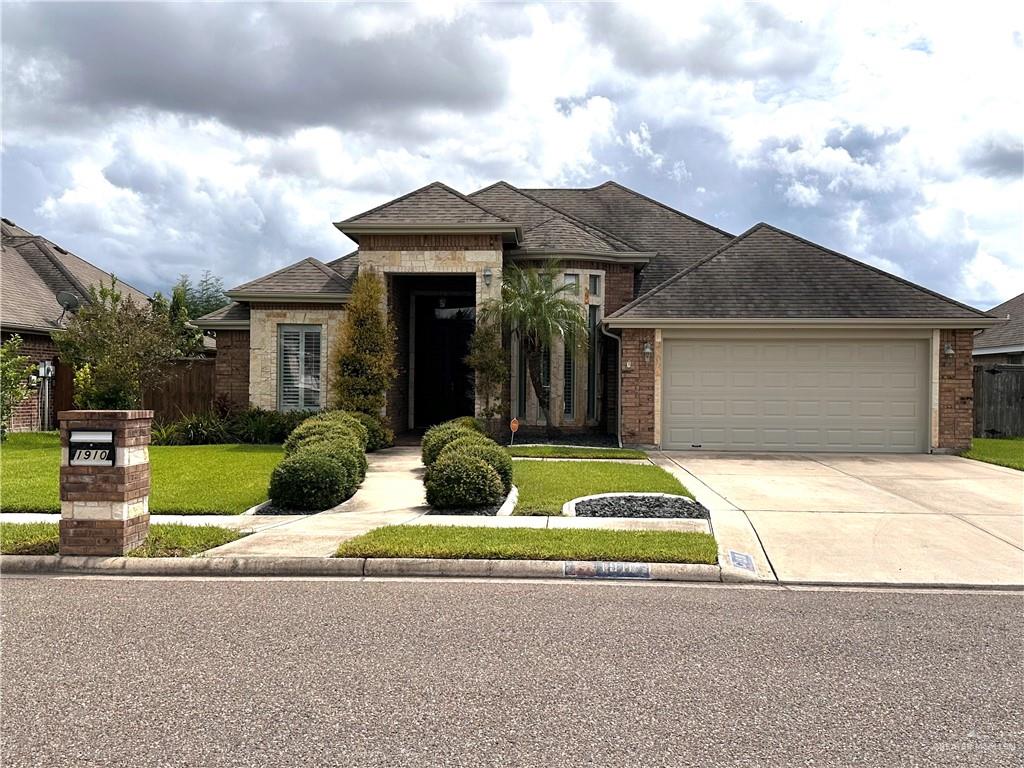 View of front of property with a garage and a front yard