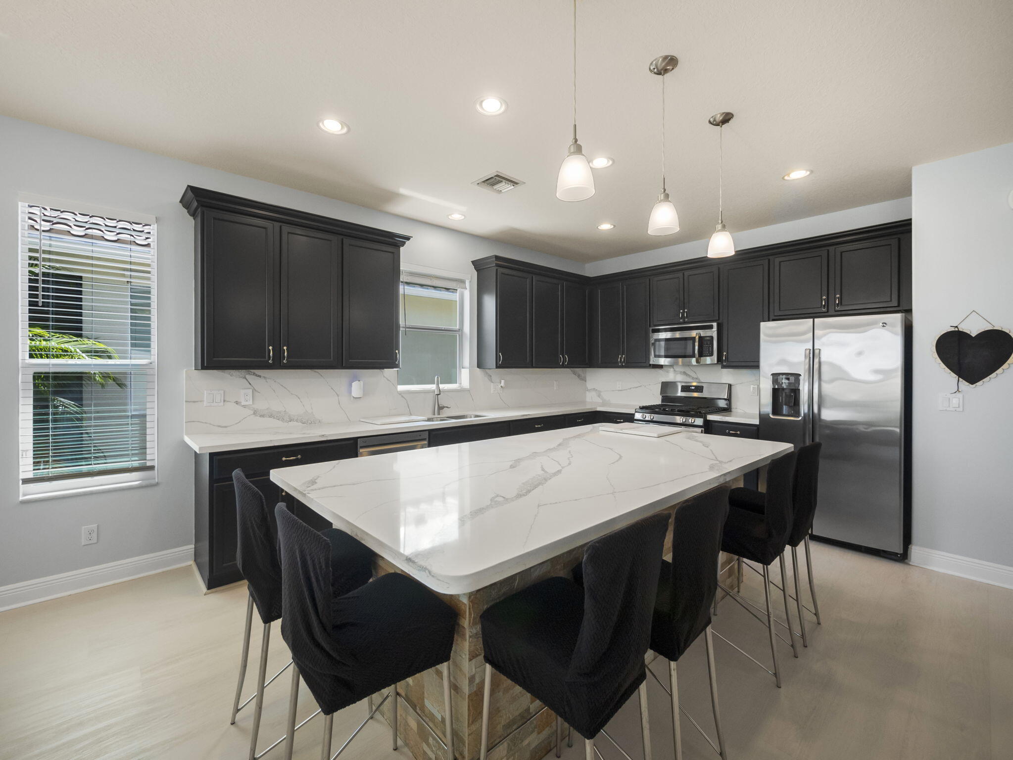 a kitchen with kitchen island white cabinets and stainless steel appliances