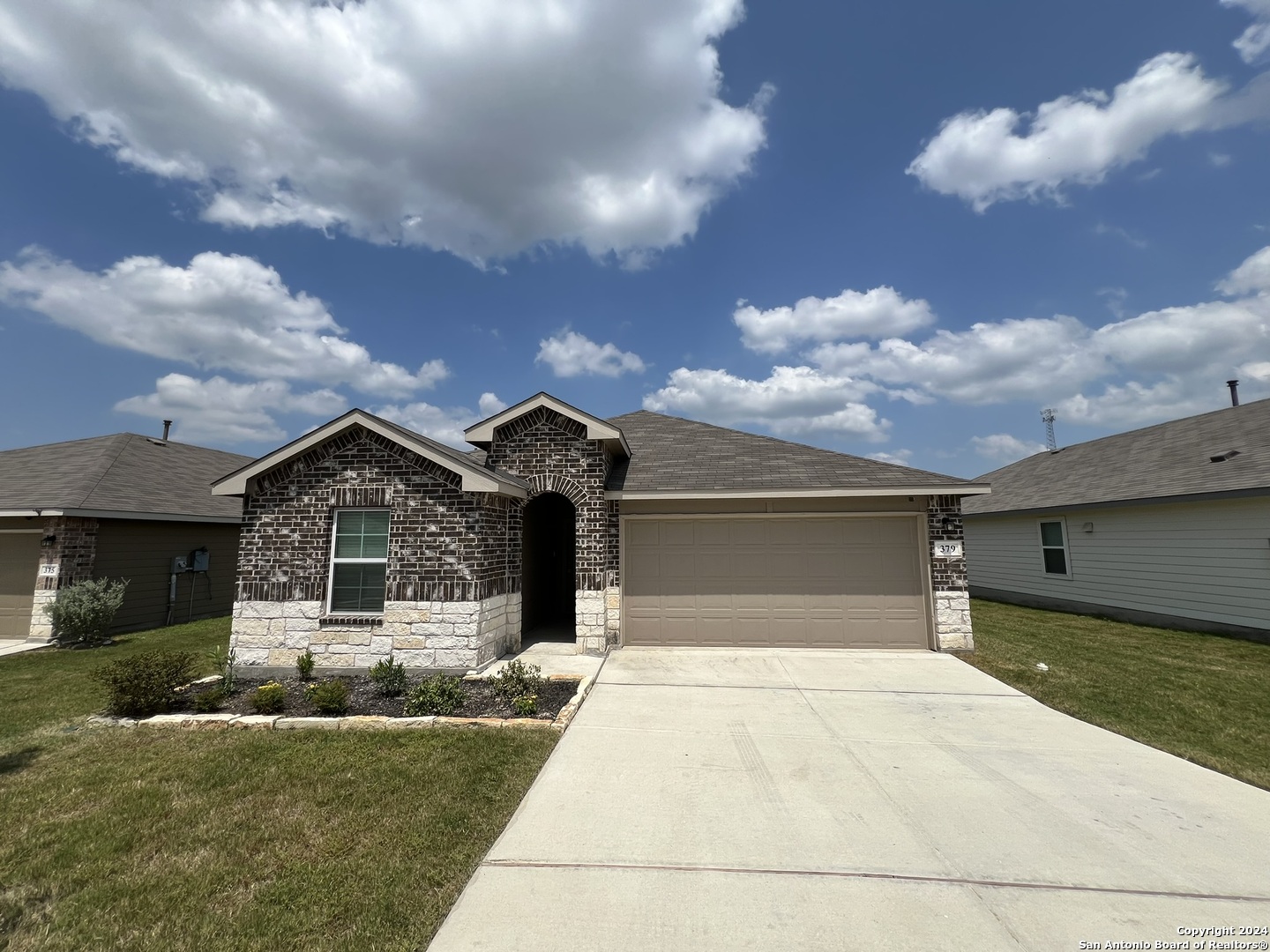 a front view of a house with a yard and garage