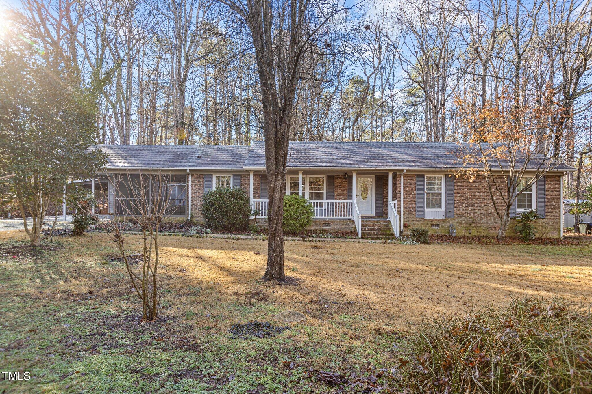 a view of a house with a yard and large tree