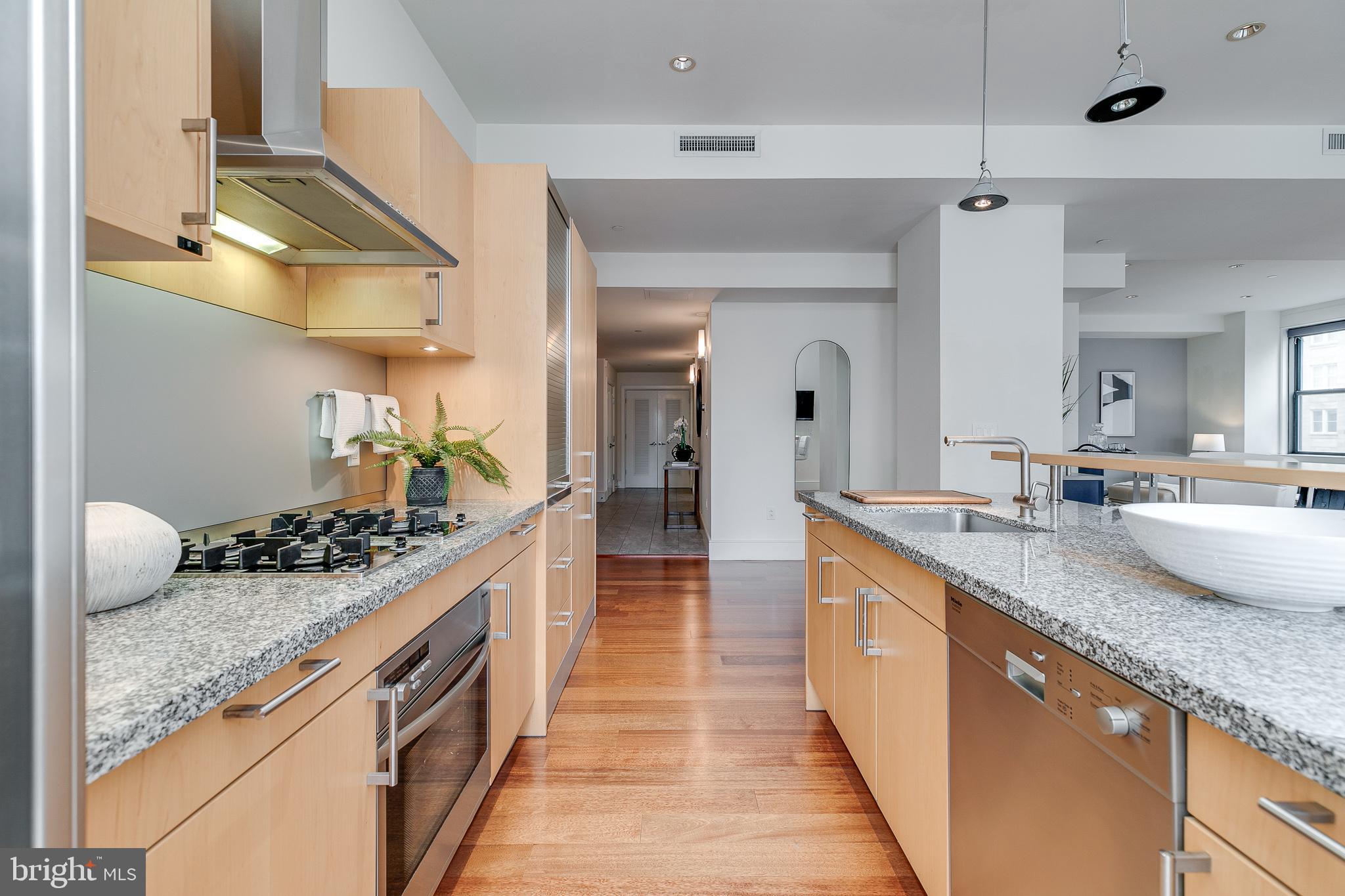 a large kitchen with stainless steel appliances granite countertop a sink and cabinets