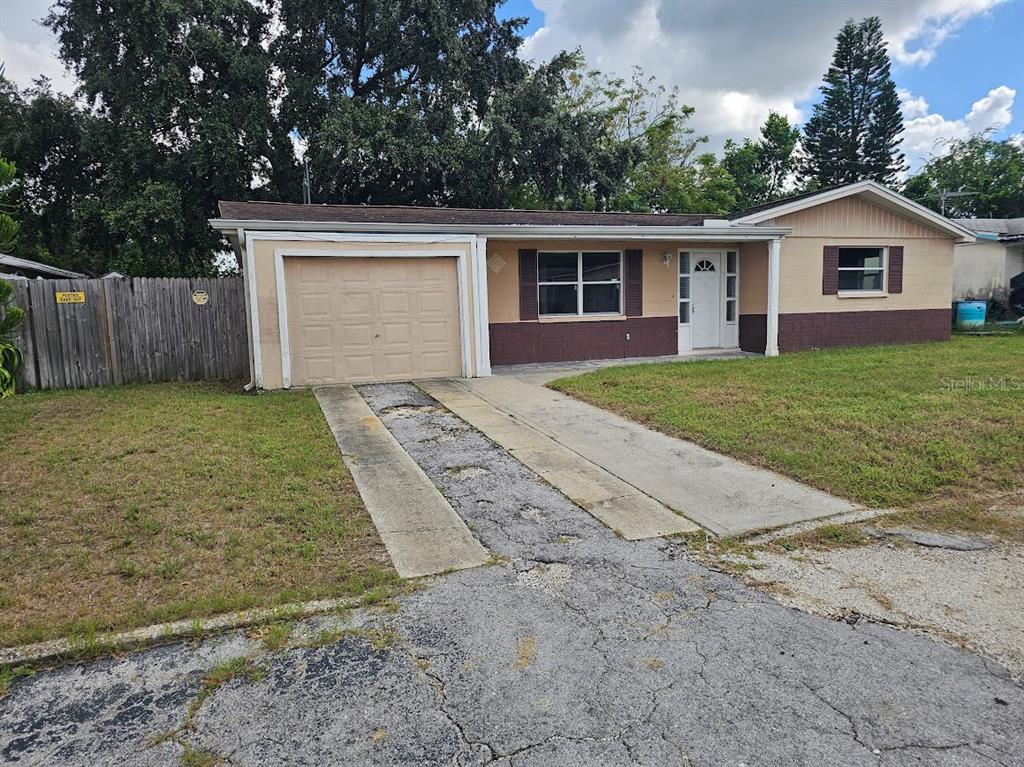 a view of a house with a yard and fence