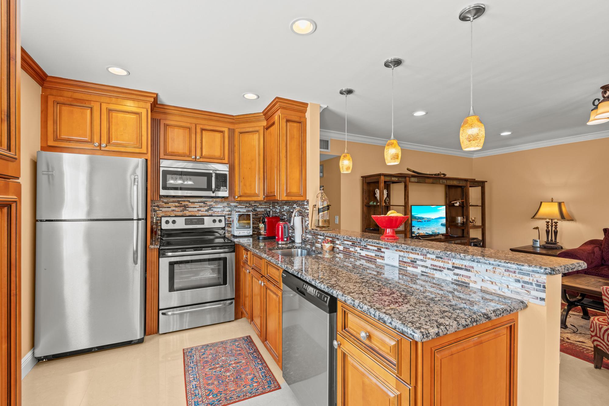 a kitchen with stainless steel appliances granite countertop a sink stove and refrigerator