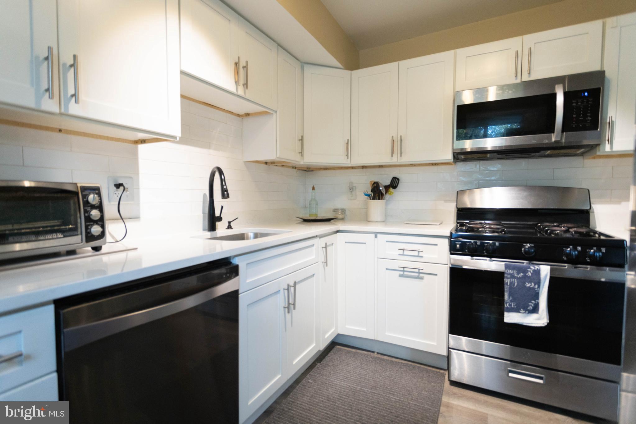 a kitchen with a sink stove and microwave