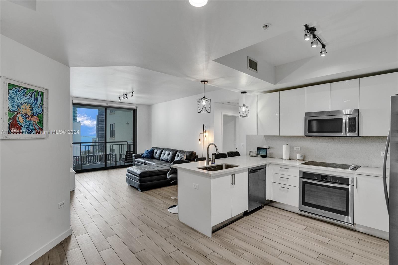 a kitchen with stainless steel appliances a stove sink microwave and cabinets