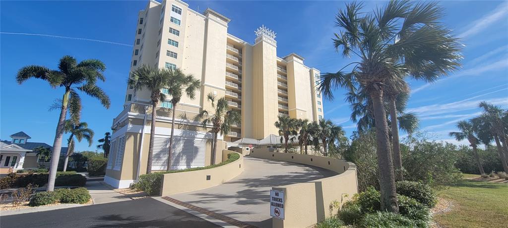 a view of a tall building with a tree and a wooden fence