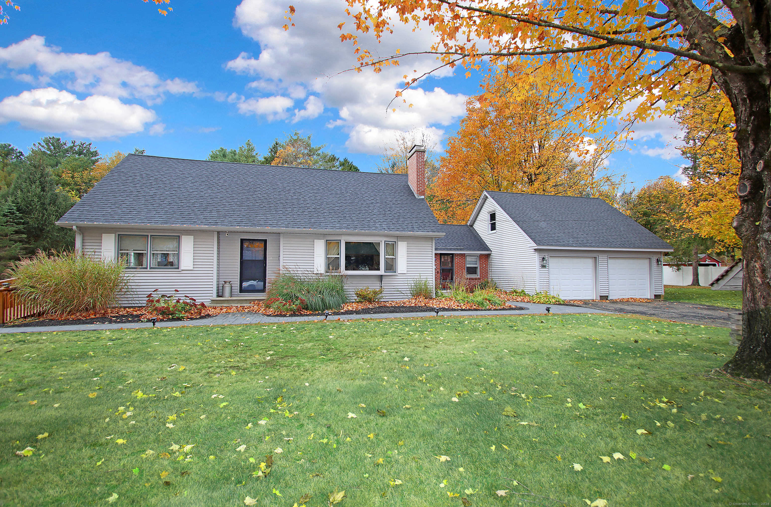 a front view of a house with a garden and trees