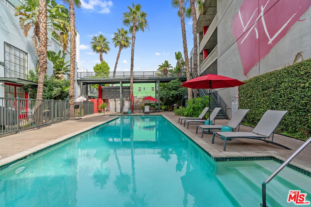 an outdoor sitting area with furniture and umbrella