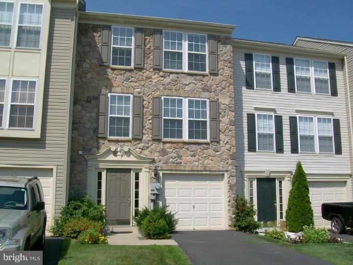 a front view of a house with yard and parking