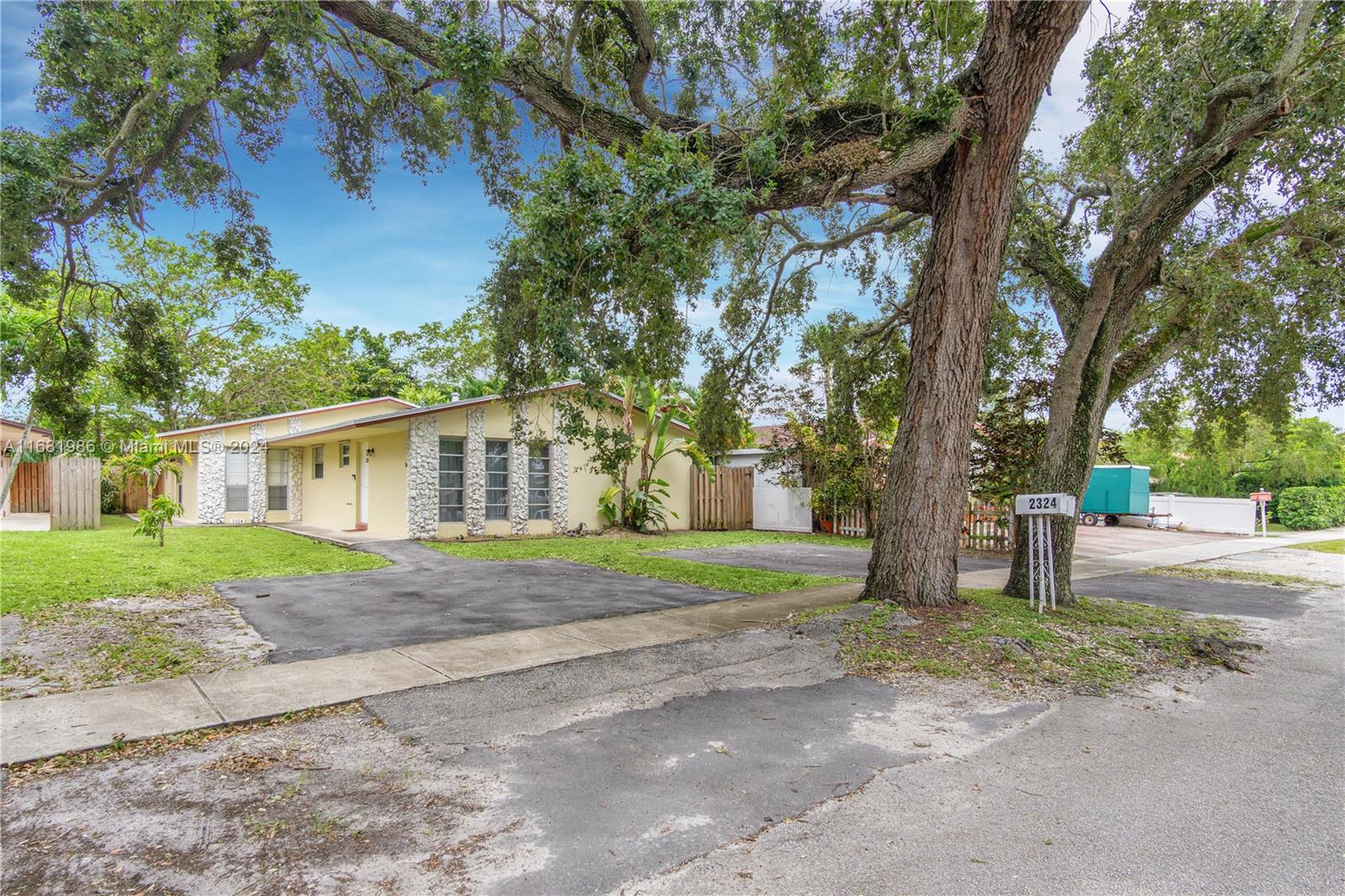 a front view of a house with a yard and trees