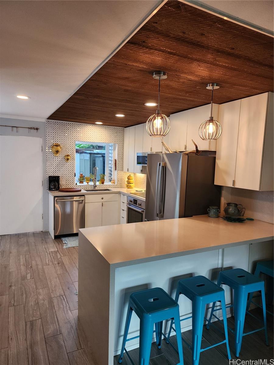 a kitchen with stainless steel appliances a table chairs and a refrigerator