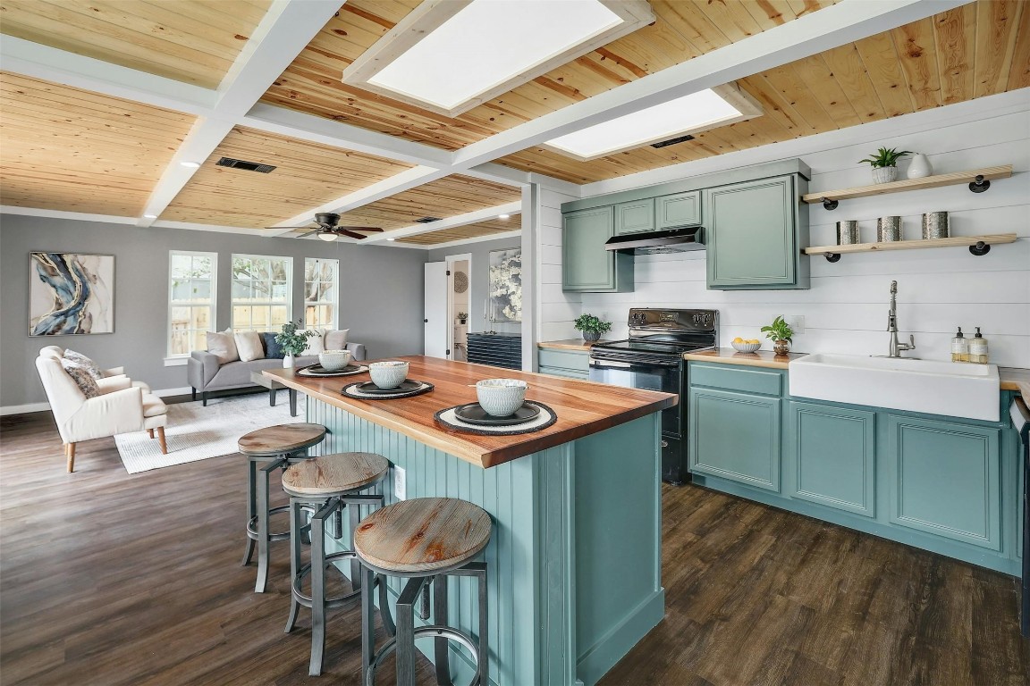 a kitchen with kitchen island granite countertop a sink and wooden floors