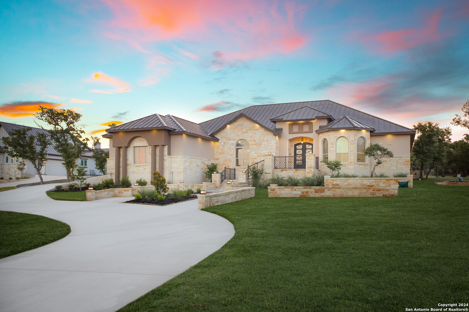 a front view of a house with a garden and yard