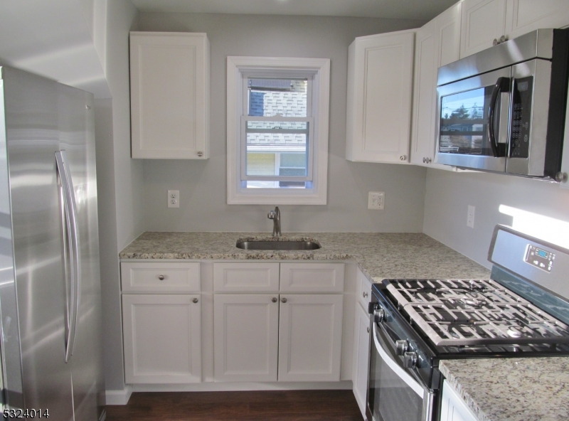 a kitchen with granite countertop a sink and a stove