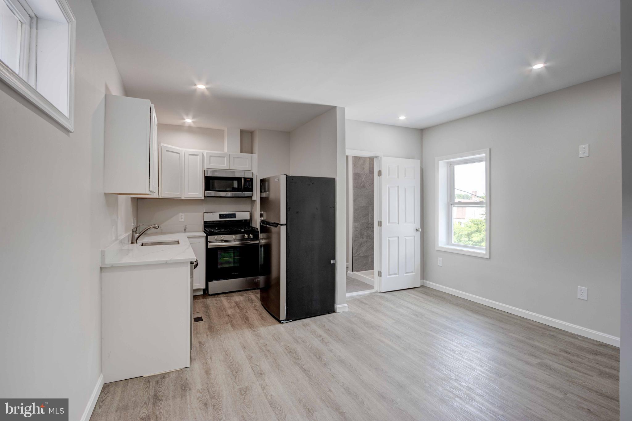 a kitchen with a refrigerator and a stove top oven