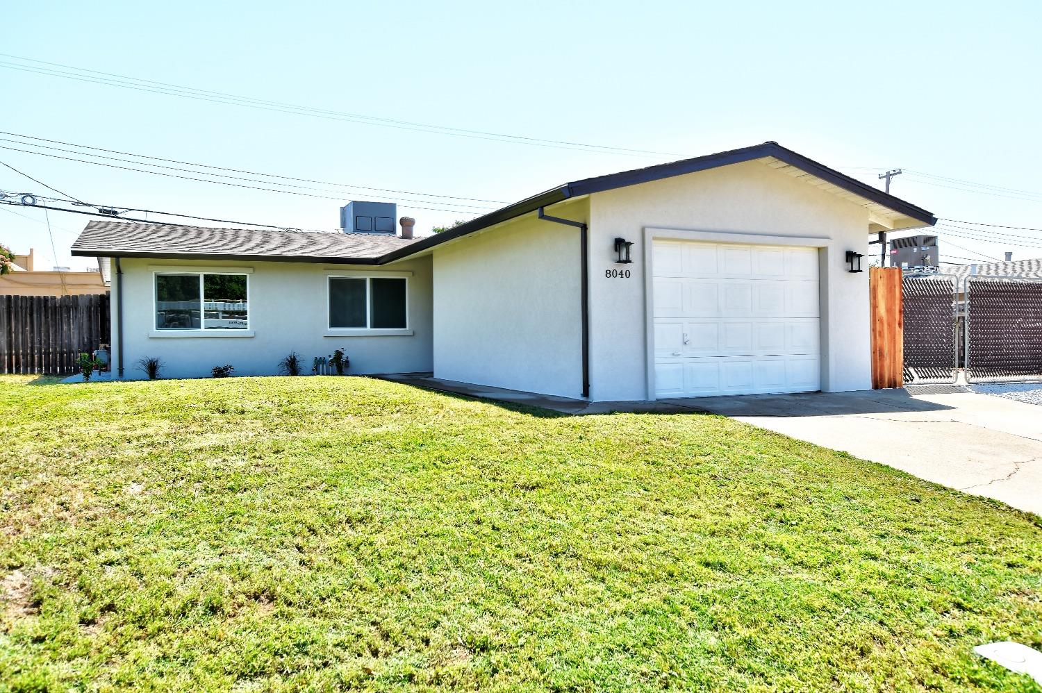 a view of a house with yard and sitting area