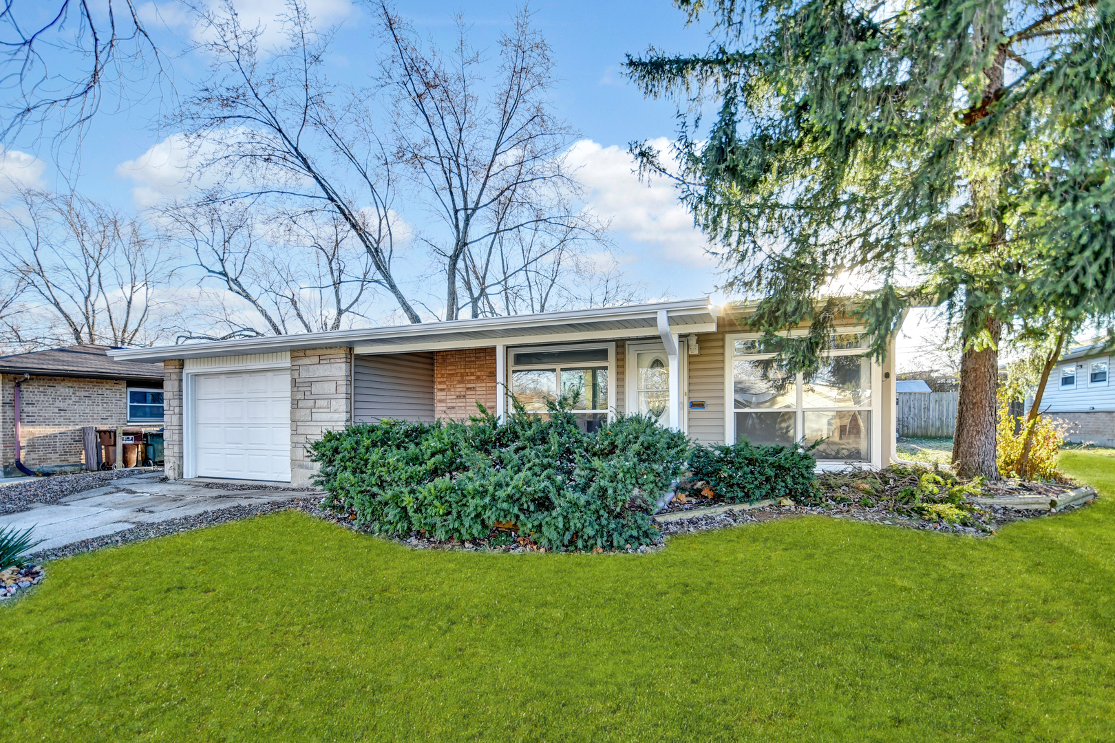 a front view of a house with a yard and trees