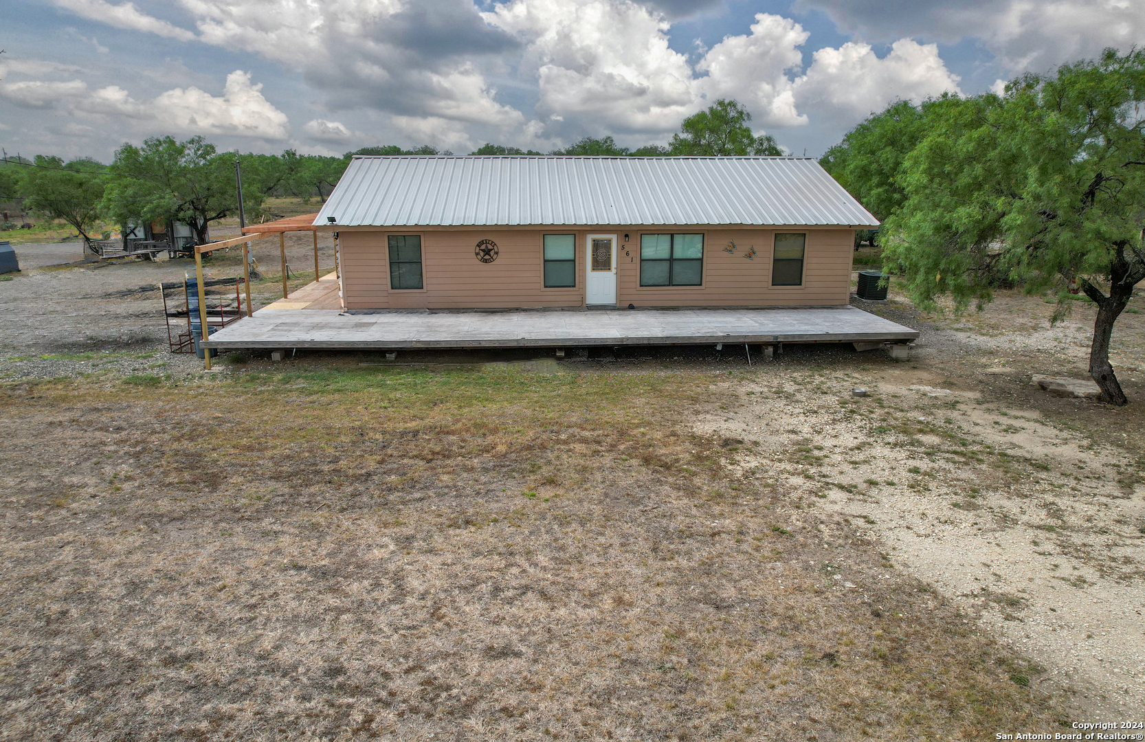 a aerial view of a house with large trees and wooden fence