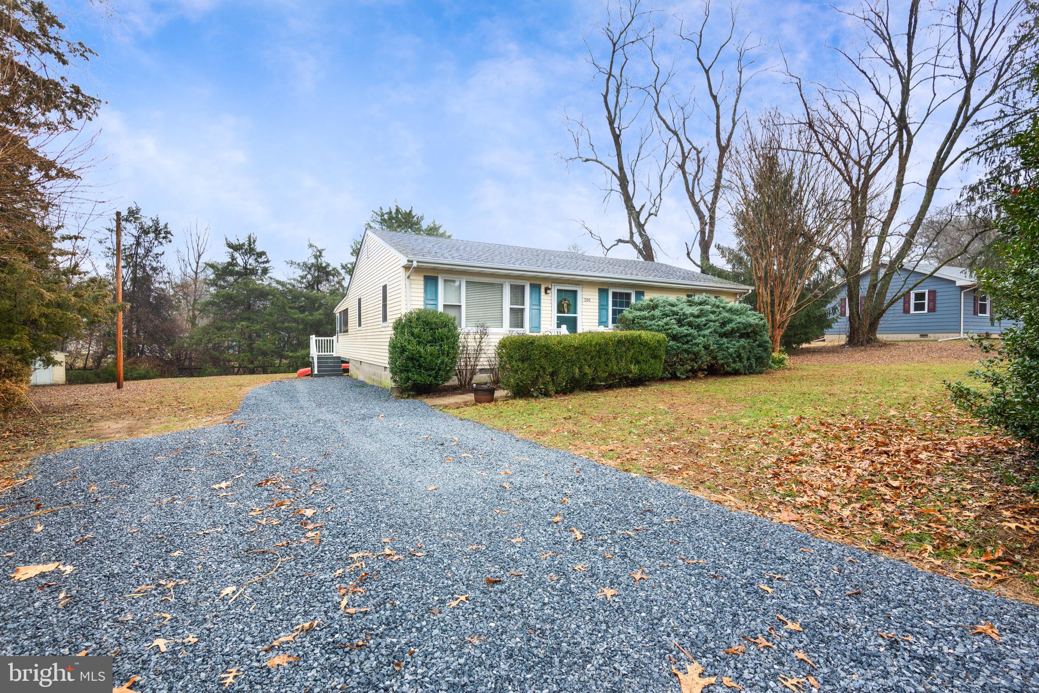 a front view of house with yard and trees around