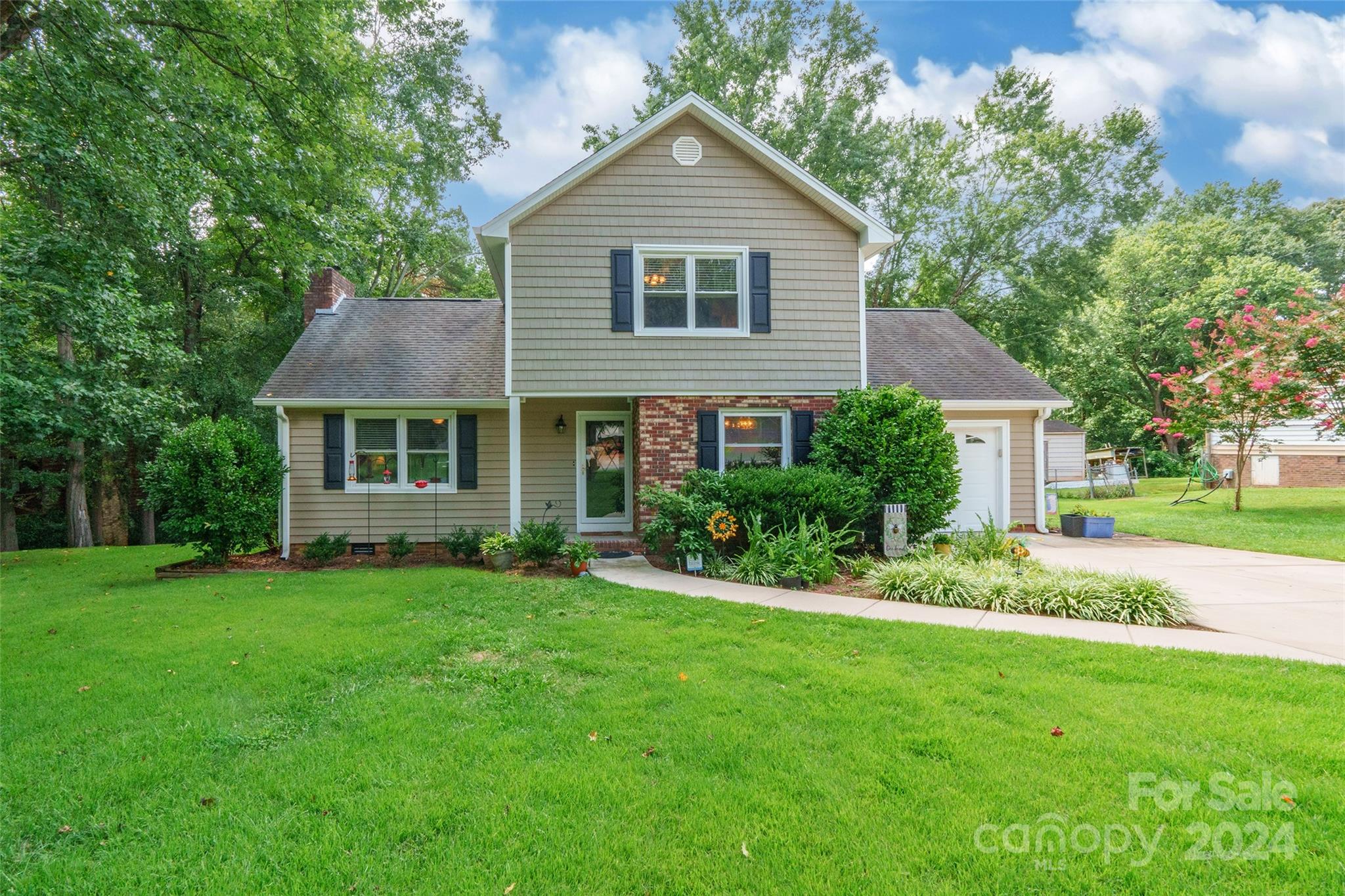 a front view of a house with a yard and trees