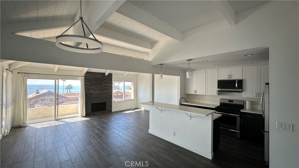 a kitchen with granite countertop a stove cabinets and wooden floor