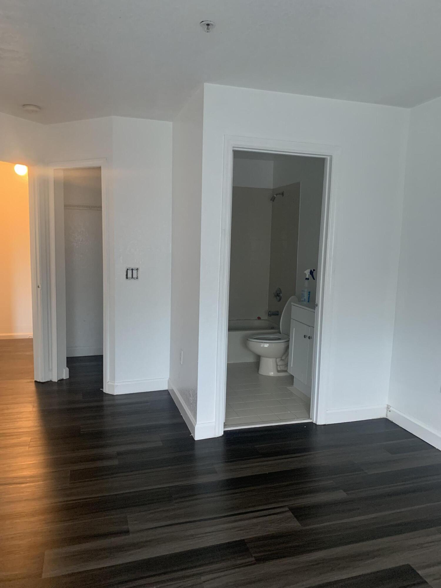 a room view with wooden floor and a bathroom