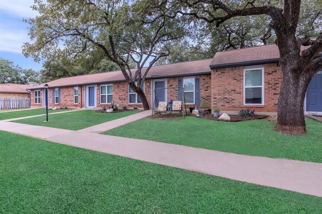 a front view of a house with a yard and trees