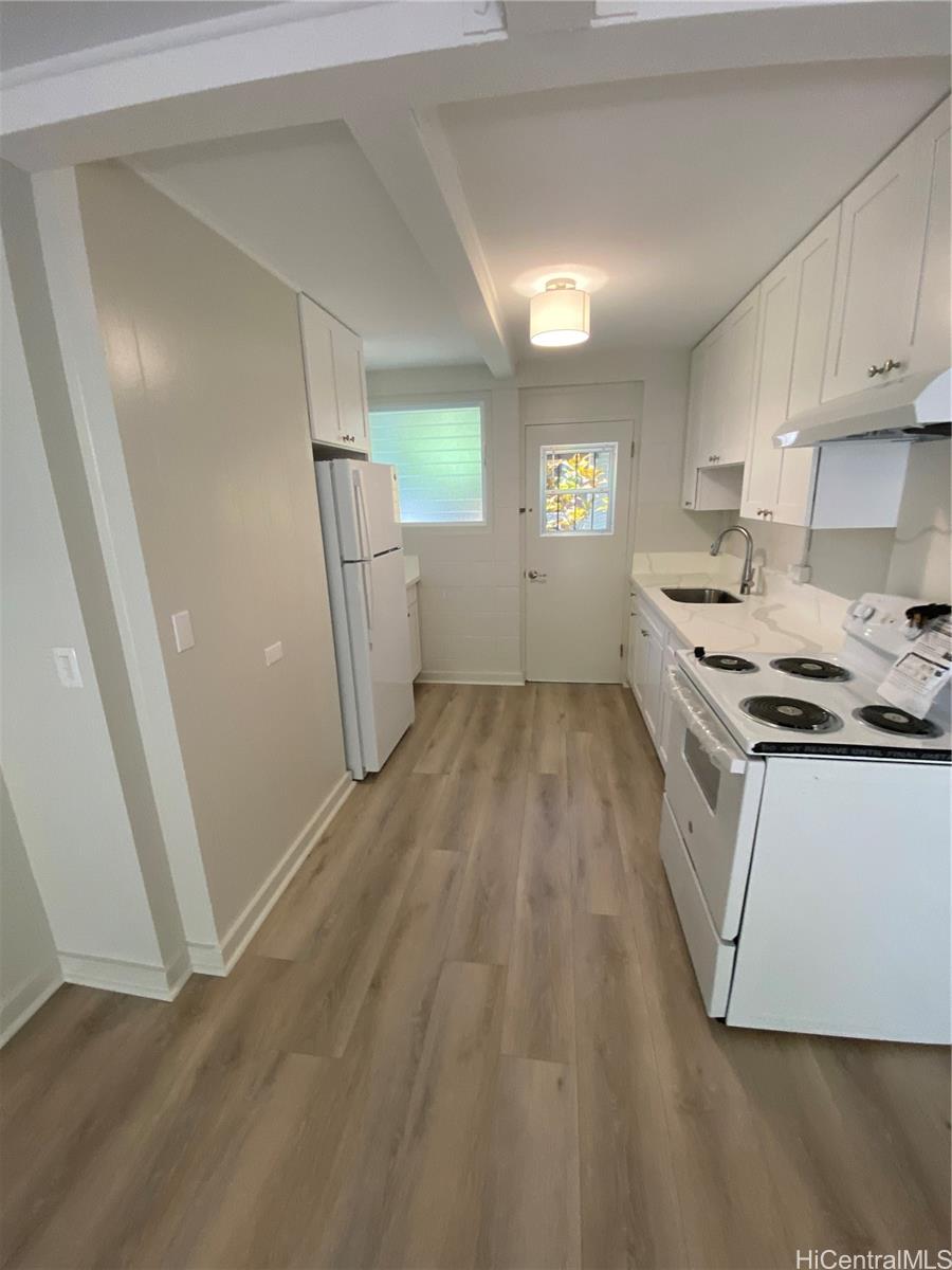 a kitchen with a sink a refrigerator and window