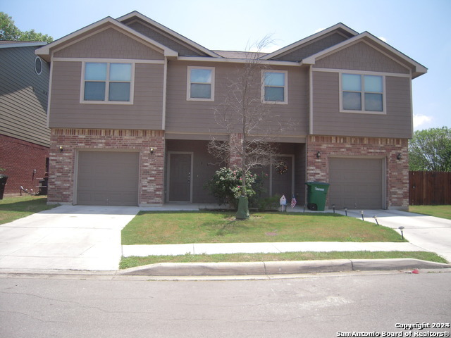 a front view of a house with a garden and yard