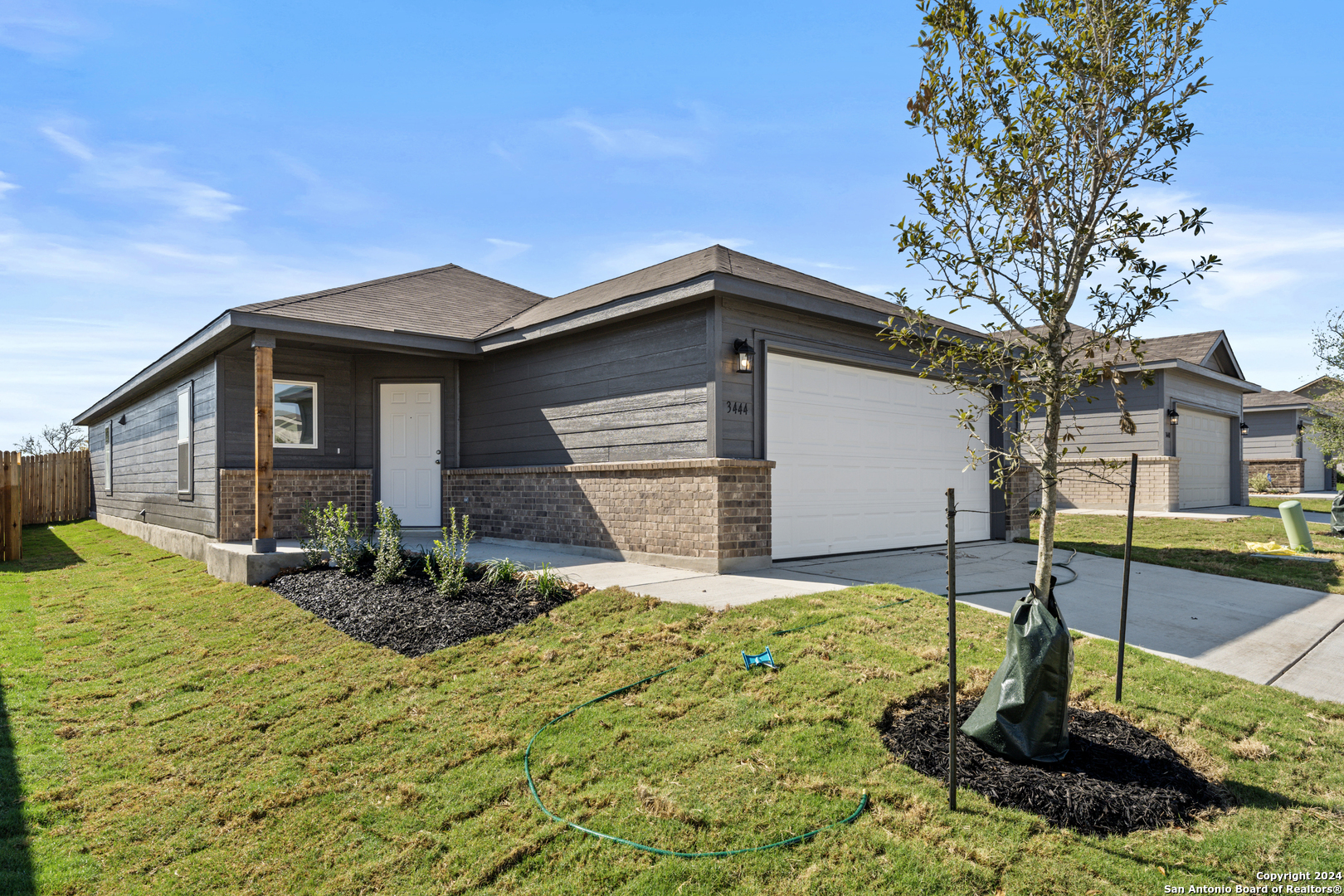 a front view of house with yard and trees in the background