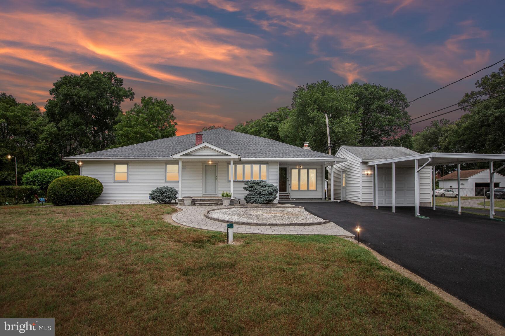 a front view of a house with a yard and trees