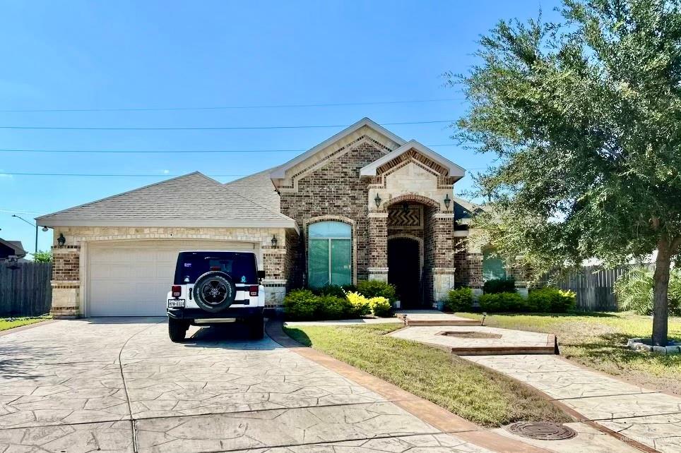 View of front of house featuring a front lawn and a garage