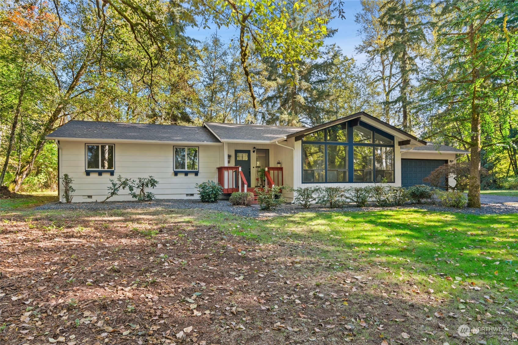 a front view of a house with a garden and trees