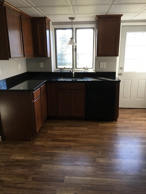 a kitchen with granite countertop a sink a window and a counter