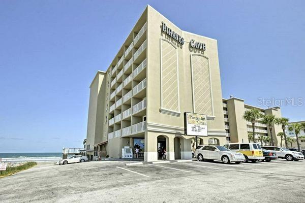 a view of a tall building with cars parked in front of it