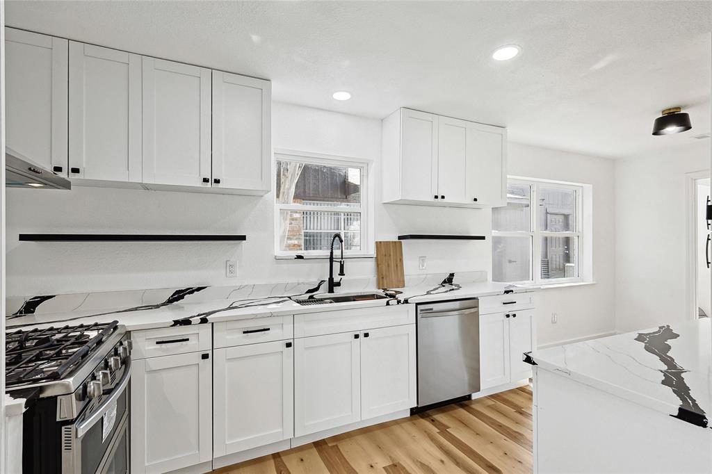 a kitchen with stainless steel appliances granite countertop a sink stove and cabinets