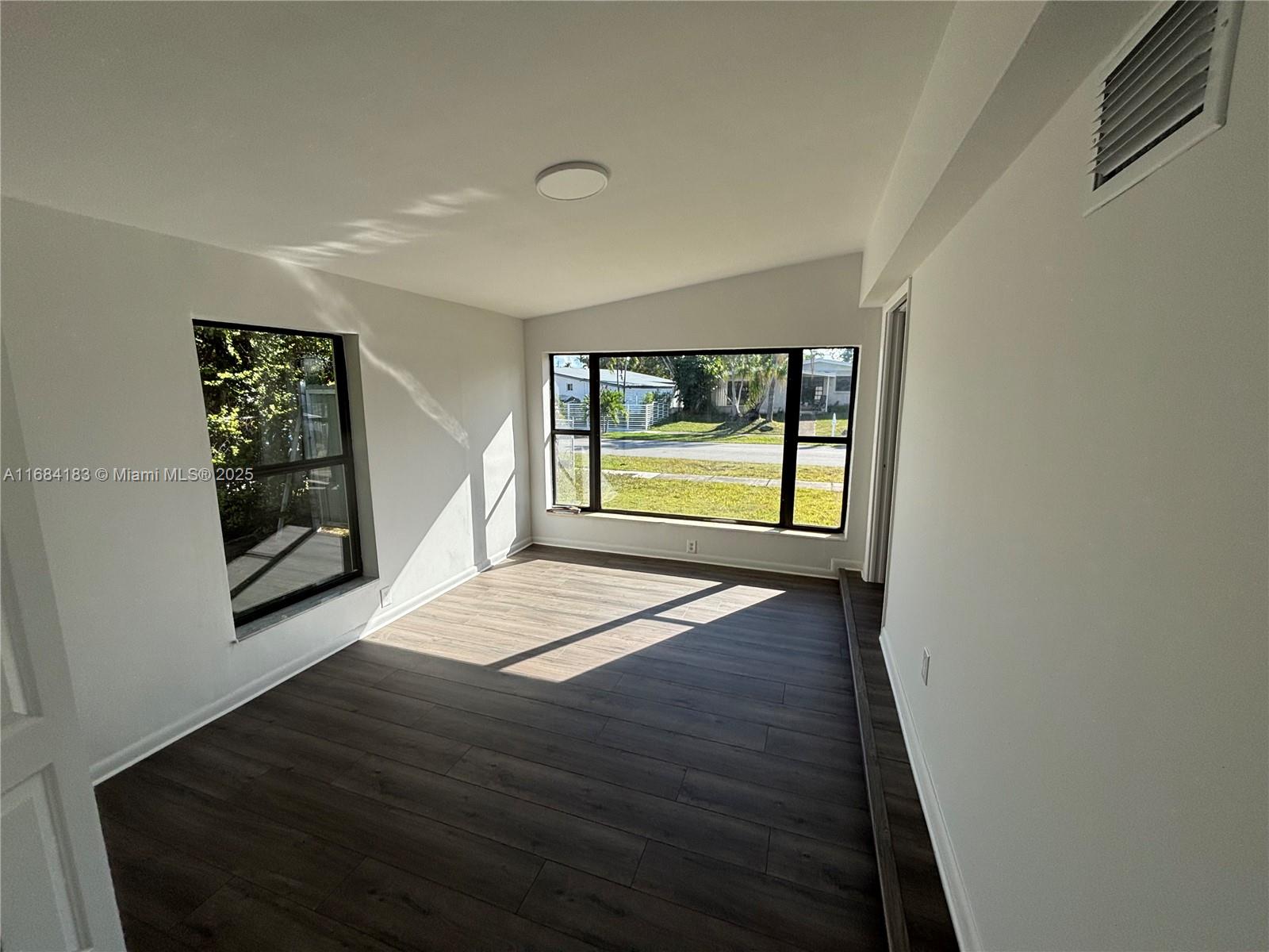 a view of an empty room with a window and a fireplace